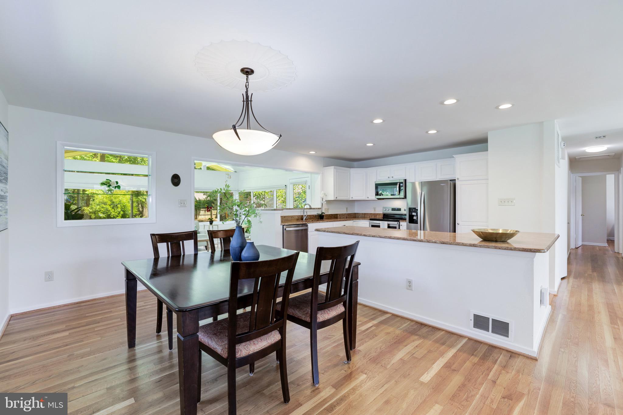 8305 Fort Hunt Road Alexandria, VA 22308 - Photo 18 of 74 a kitchen with stainless steel appliances granite countertop a dining table chairs and white cabinets