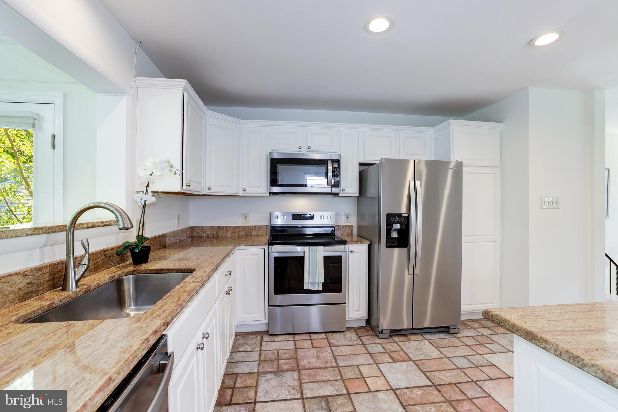 8305 Fort Hunt Road Alexandria, VA 22308 - Photo 21 of 74 a kitchen with stainless steel appliances granite countertop a sink a stove a refrigerator cabinets and a counter top space