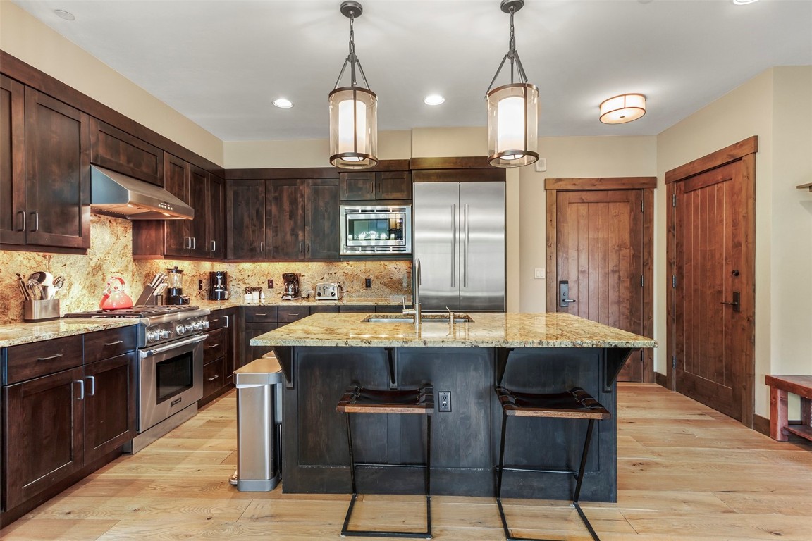 610 Columbine Road, Unit 6306 Breckenridge, CO 80424 - Photo 6 of 38 a kitchen with stainless steel appliances granite countertop a sink a stove and a wooden floors