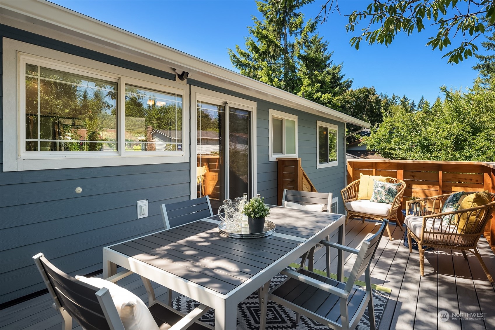 209 225th Place Southwest Bothell, WA 98021 - Photo 11 of 29 a view of a patio with a dining table and chairs with wooden floor and fence
