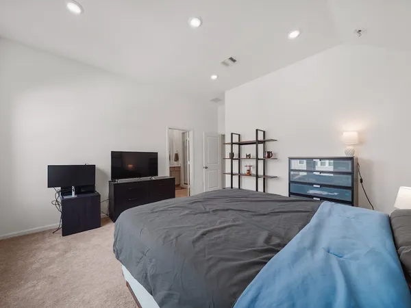 a large bedroom with a bed and furniture