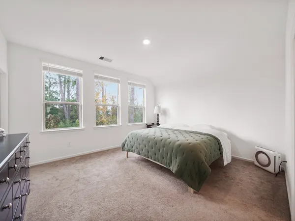 a spacious bedroom with a bed and a window