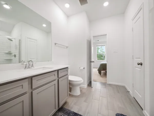 a spacious bathroom with a toilet sink and mirror
