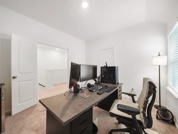 a view of a workspace with furniture and a air conditioner vent