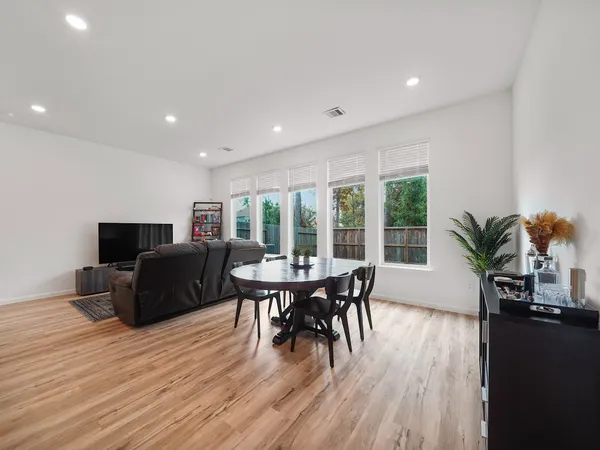 a dining room with furniture window and wooden floor