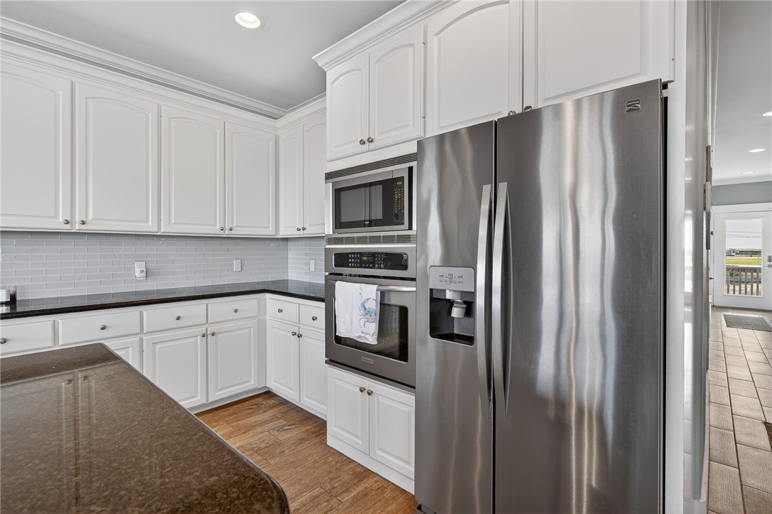 838 Rattlesnake Point Road Rockport, TX 78382 - Photo 18 of 40 a kitchen with stainless steel appliances granite countertop a refrigerator sink and cabinets