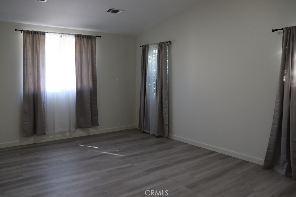 16731 Parthenia Street, Unit 3 Northridge, CA 91343 - Photo 31 of 37 an empty room with wooden floor and windows