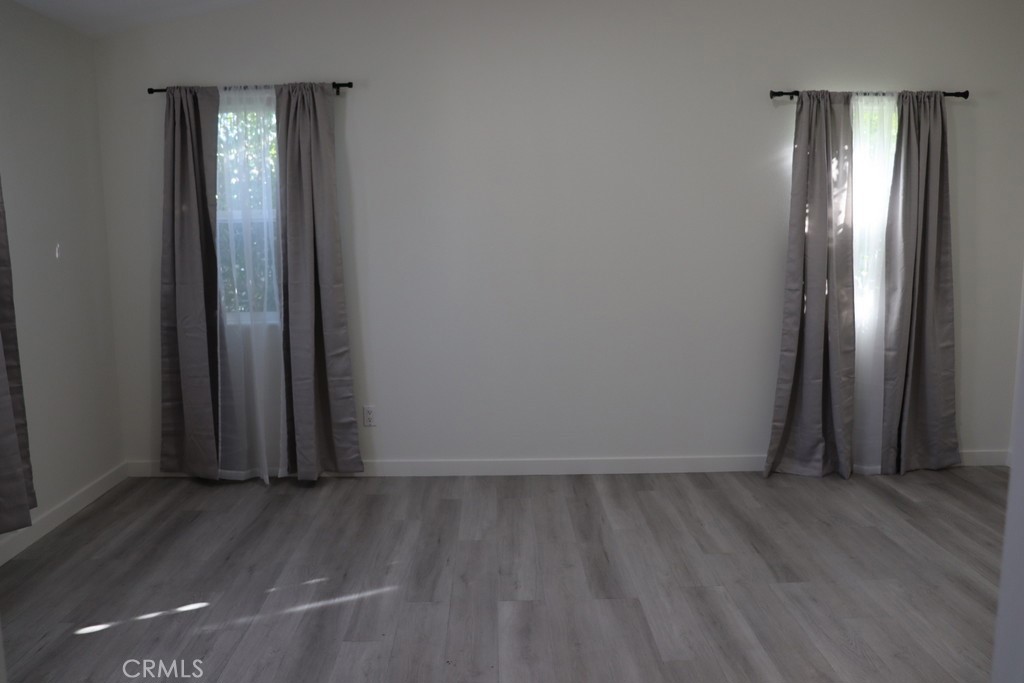 16731 Parthenia Street, Unit 3 Northridge, CA 91343 - Photo 32 of 37 an empty room with wooden floor and mirror