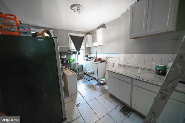 a kitchen with sink refrigerator and cabinets
