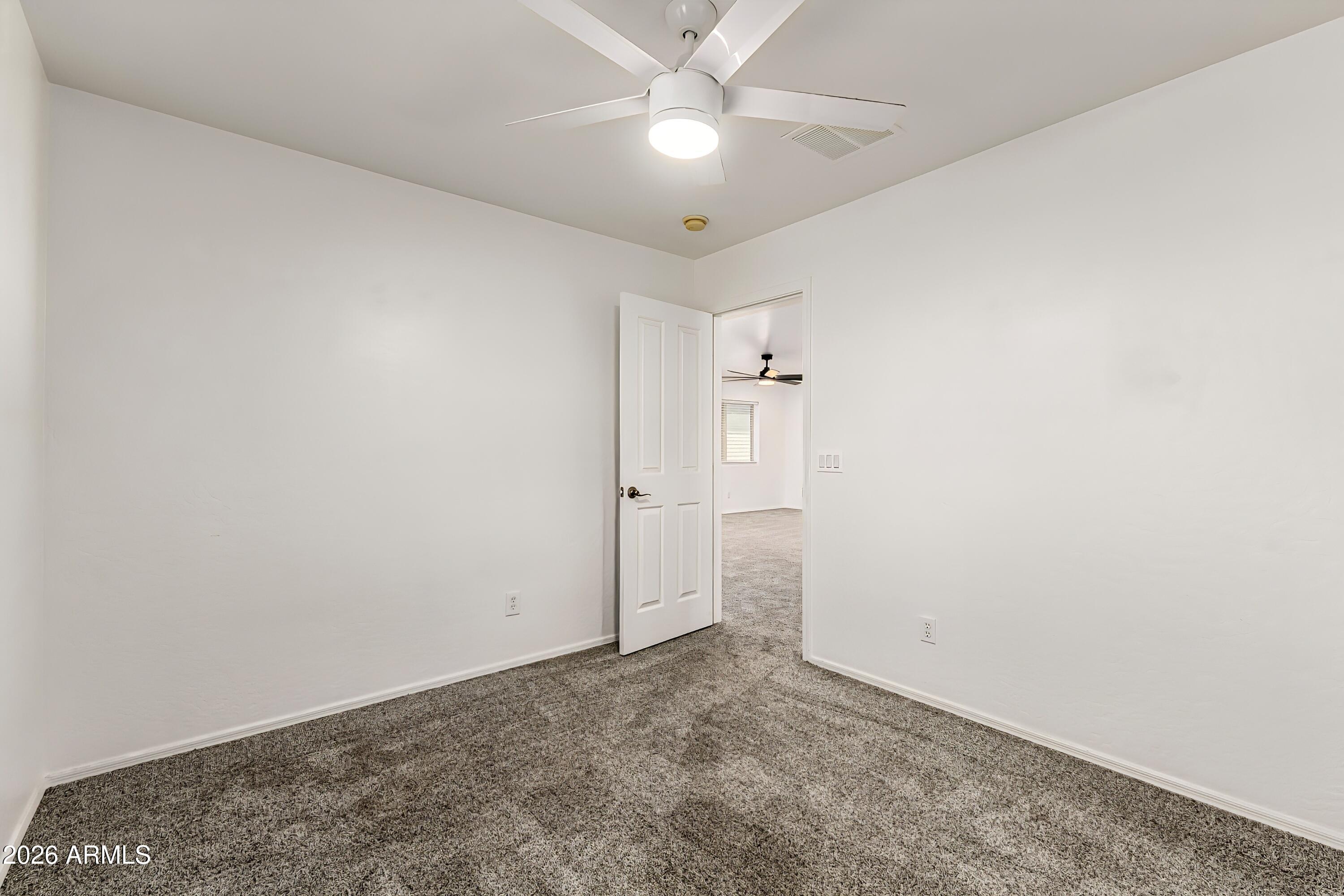 4208 South Sawmill Road Gilbert, AZ 85297 - Photo 31 of 46 an empty room with a ceiling fan and a window