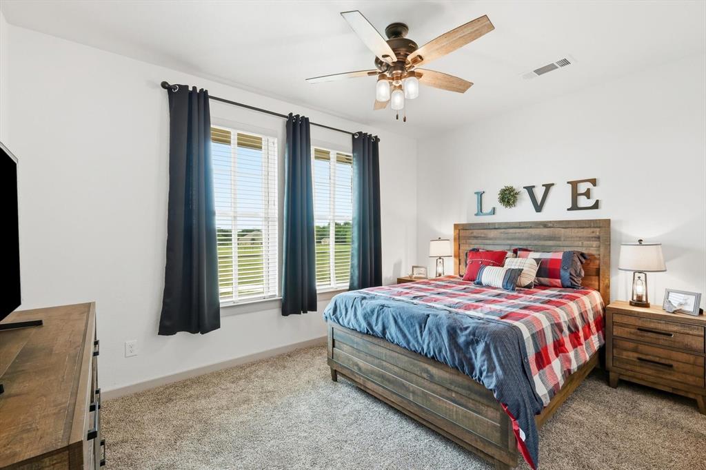 6020 Honeysuckle Road Midlothian, TX 76065 - Photo 24 of 39 Carpeted bedroom featuring a ceiling fan with light fixture, dual windows, and light-colored walls