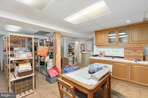 a kitchen with a stove a sink dishwasher a dining table and chairs with wooden cabinets