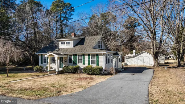 a front view of a house with a yard and potted plants