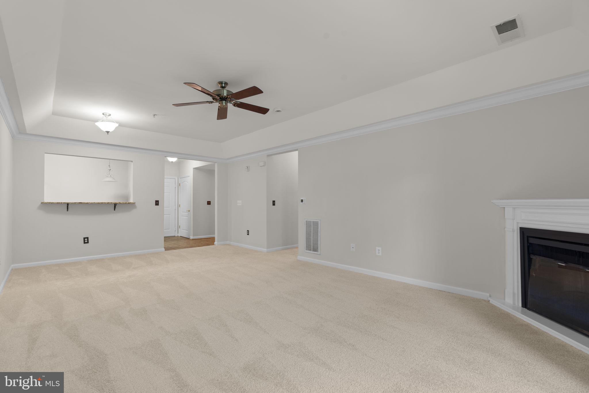7315 Maplecrest Road, Unit 104 Elkridge, MD 21075 - Photo 13 of 58 an empty room with chandelier fan and windows