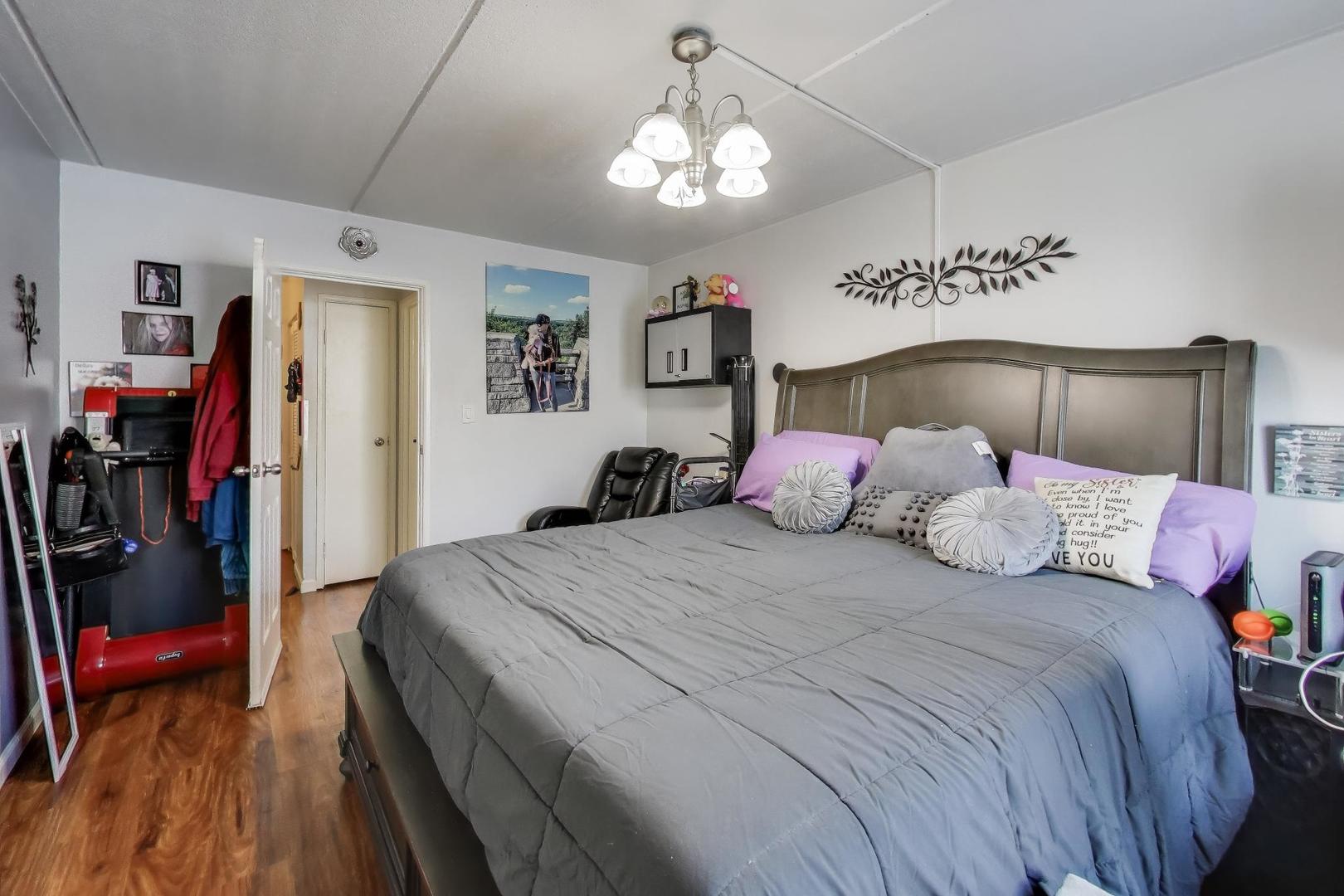 841 North York Street, Unit 109 Elmhurst, IL 60126 - Photo 11 of 34 a bedroom with a bed and a chandelier