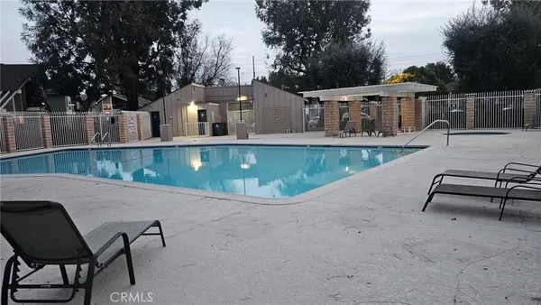 a view of a house with pool and chairs