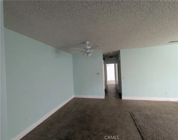 an empty room with an empty space and a kitchen