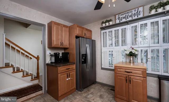 a kitchen with stainless steel appliances granite countertop a refrigerator a stove and a sink with wooden cabinets