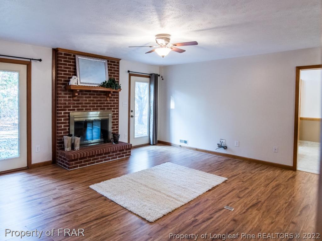 2601 Calloway Road Raeford, NC 28376 - Photo 6 of 34 a living room with hard wood floors and a fireplace