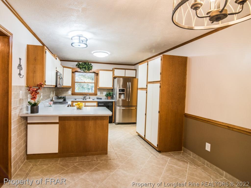 2601 Calloway Road Raeford, NC 28376 - Photo 8 of 34 a kitchen with stainless steel appliances granite countertop a refrigerator a stove and a sink with large mirror