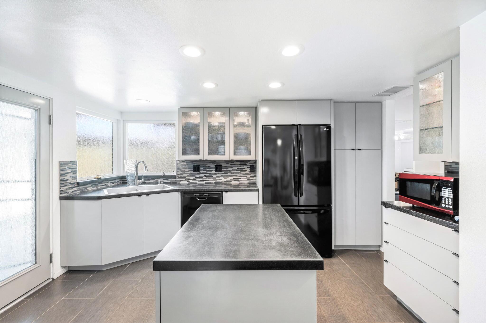 71888 Vista Del Rio Rancho Mirage, CA 92270 - Photo 9 of 36 a kitchen with a refrigerator and white cabinets