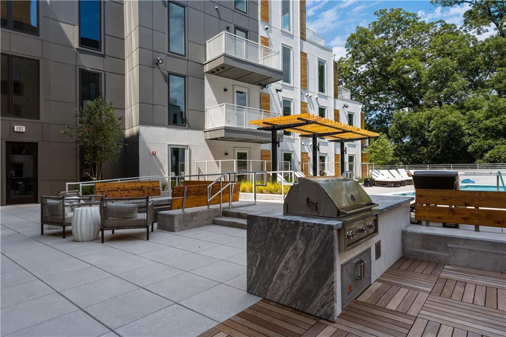 775 Juniper Street Northeast, Unit 404 Atlanta, GA 30308 - Photo 15 of 22 a view of a patio with couches table and chairs under an umbrella with a barbeque