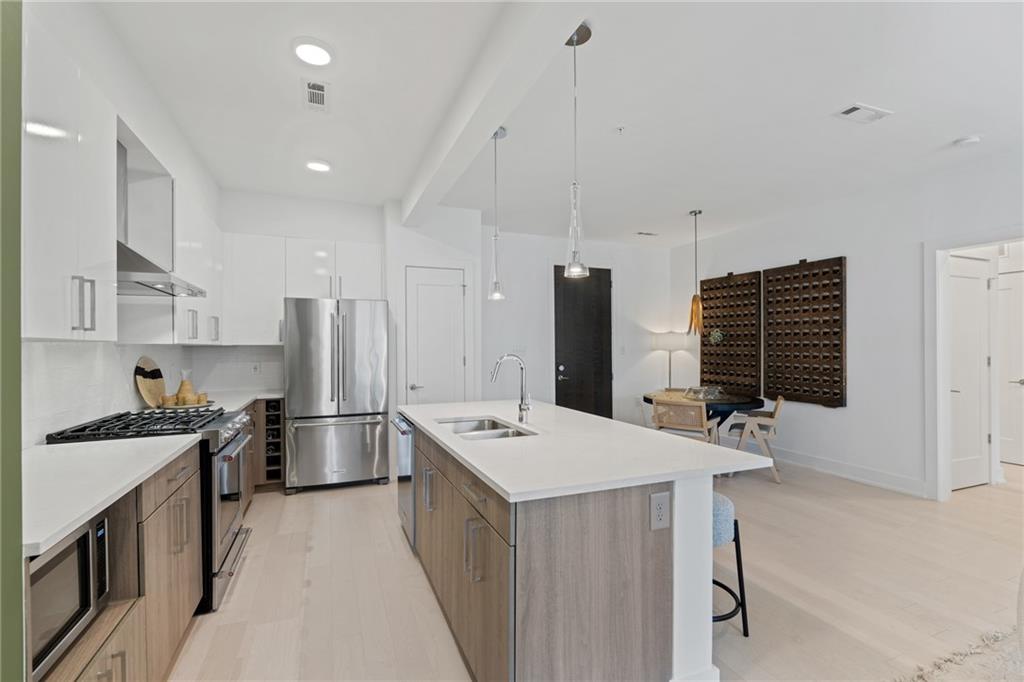 775 Juniper Street Northeast, Unit 404 Atlanta, GA 30308 - Photo 7 of 22 a kitchen that has a refrigerator a stove and a sink with wooden floor