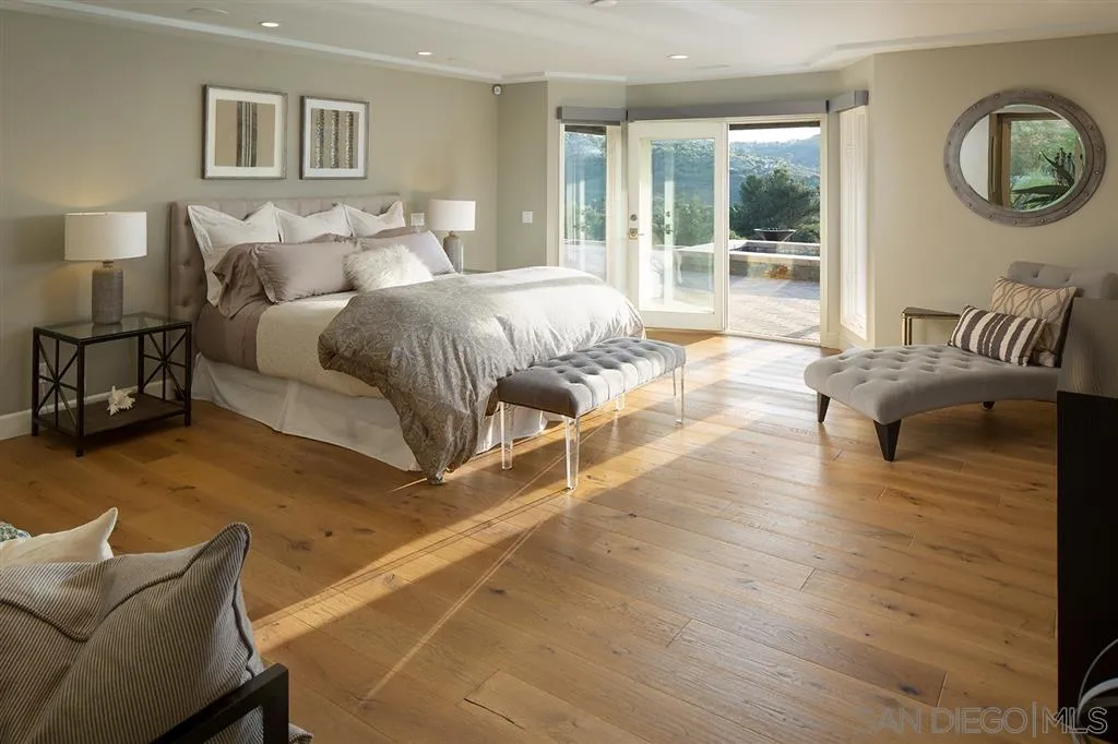 7190 Vía Mariposa Norte Bonsall, CA 92003 - Photo 12 of 25 a bedroom with a bed and wooden floor