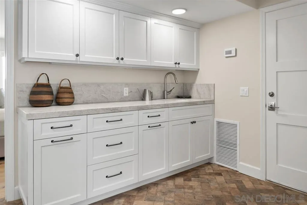 7190 Vía Mariposa Norte Bonsall, CA 92003 - Photo 20 of 25 a kitchen with white cabinets and sink