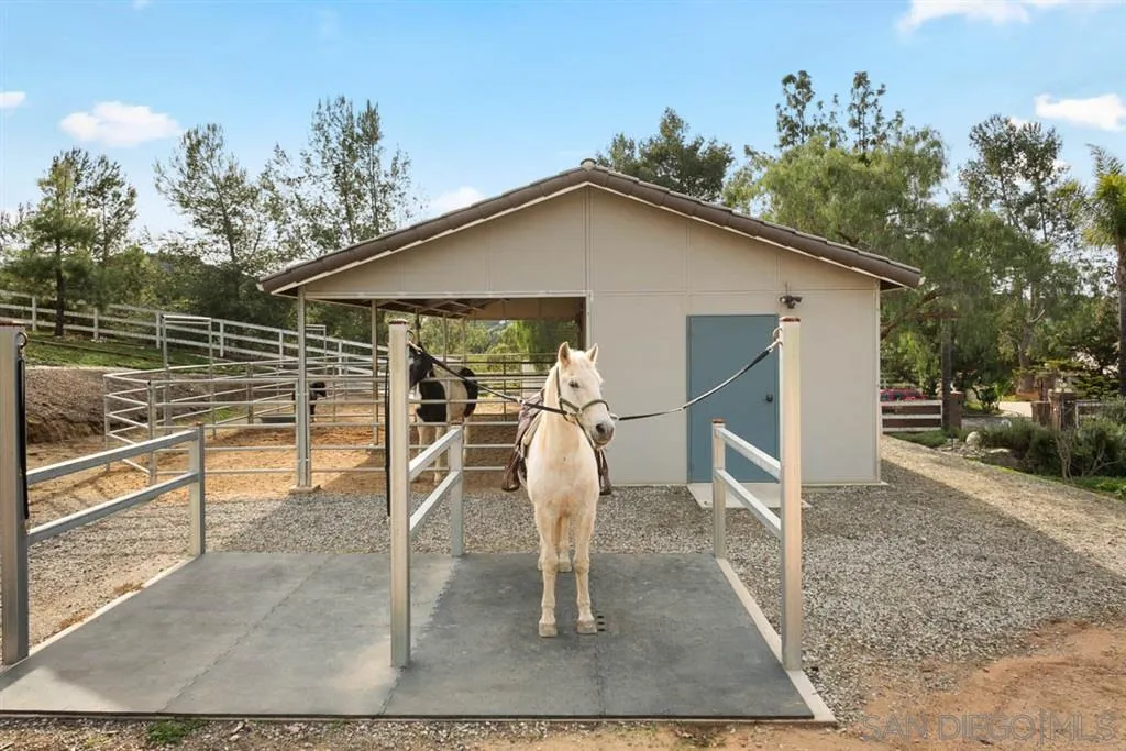 7190 Vía Mariposa Norte Bonsall, CA 92003 - Photo 22 of 25 a view of a patio with table and chairs with wooden floor and fence