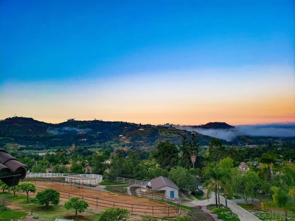 7190 Vía Mariposa Norte Bonsall, CA 92003 - Photo 23 of 25 a view of a grassy area with mountains and a houses