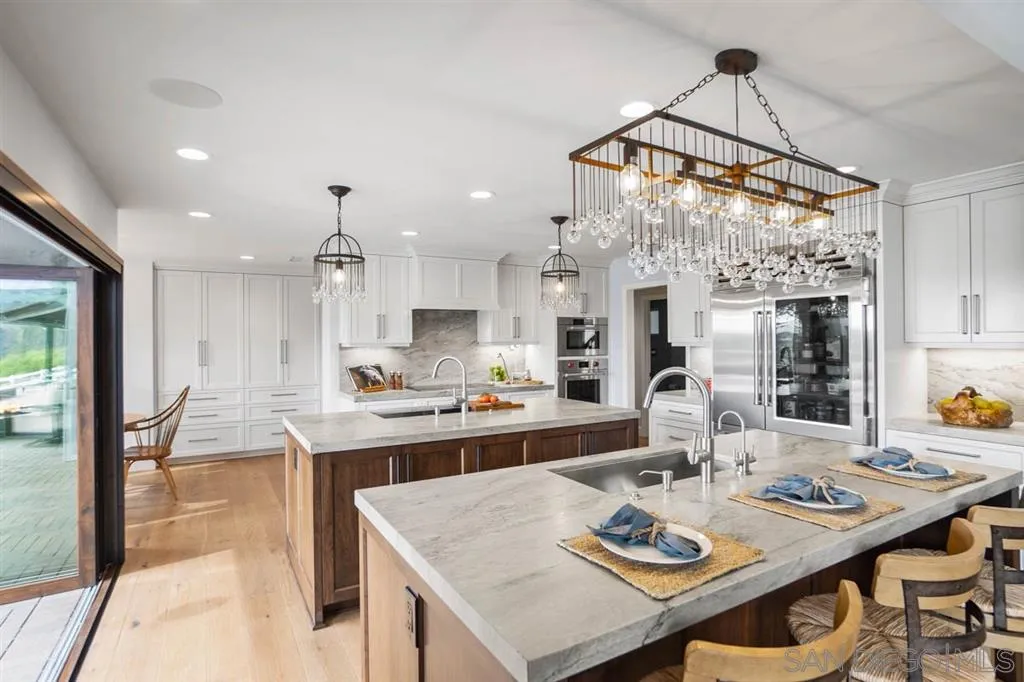 7190 Vía Mariposa Norte Bonsall, CA 92003 - Photo 7 of 25 a open dining room with stainless steel appliances kitchen island a table and chairs