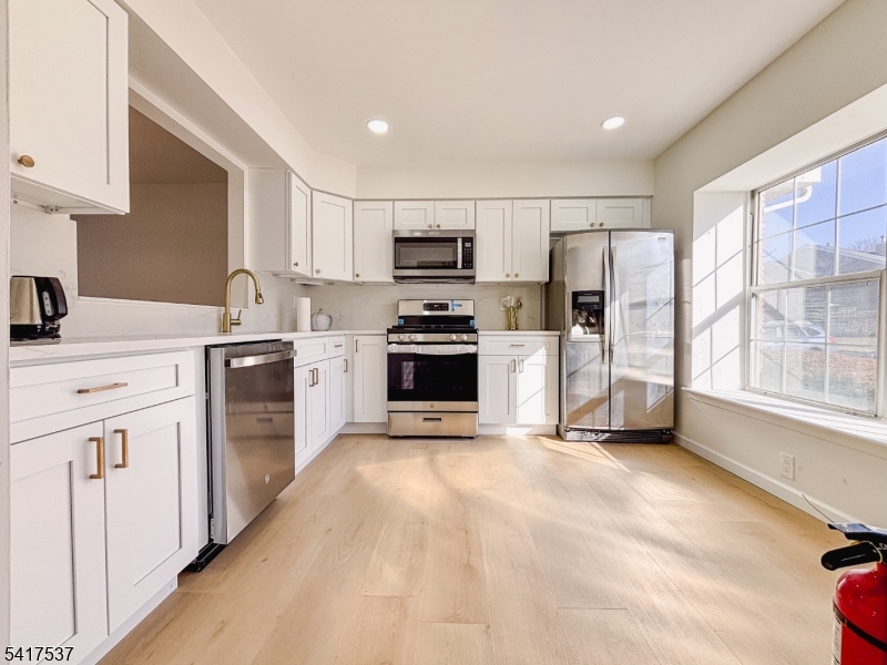 386 Inwood Court Somerset, NJ 08873 - Photo 2 of 34 a kitchen with granite countertop a refrigerator stove and sink