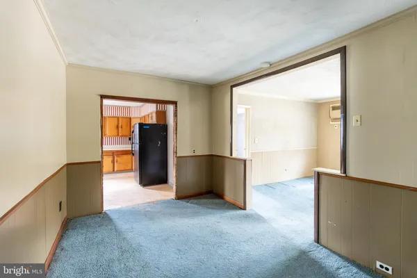 an empty room with closet and a hallway