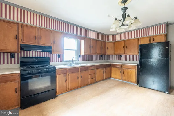 a kitchen with granite countertop a refrigerator a sink dishwasher a stove and a microwave oven