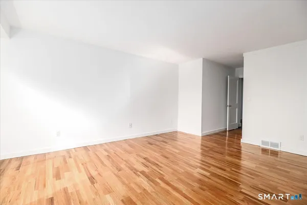 a view of an empty room with wooden floor