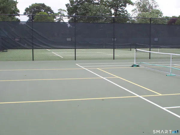 an aerial view of residential houses with outdoor space and trees