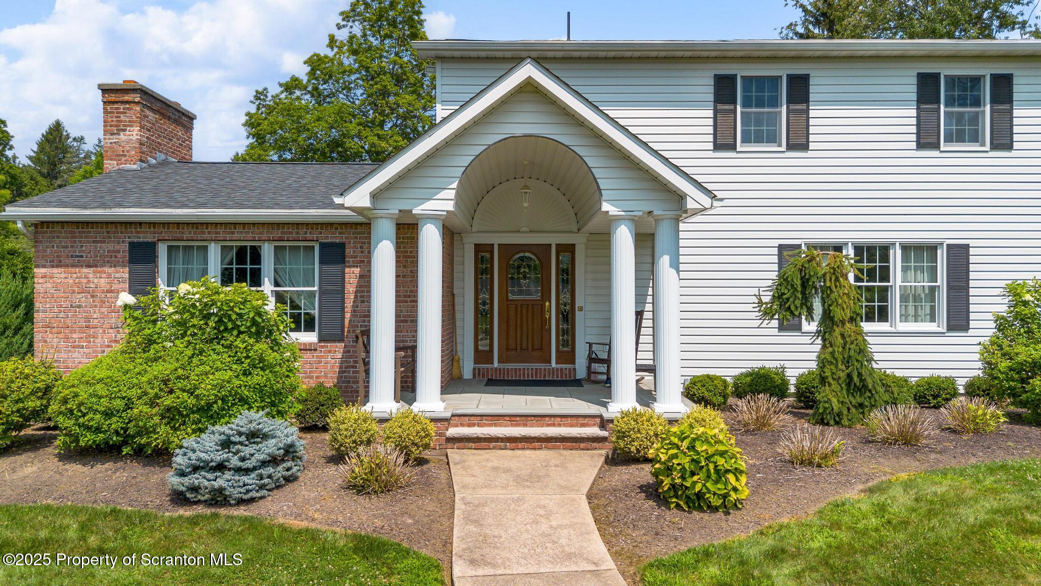 321 North Abington Road Clarks Green, PA 18411 - Photo 62 of 78 a view of a brick house with potted plants and a table