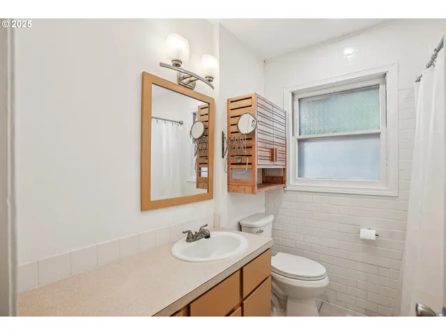 a bathroom with a toilet a sink and mirror