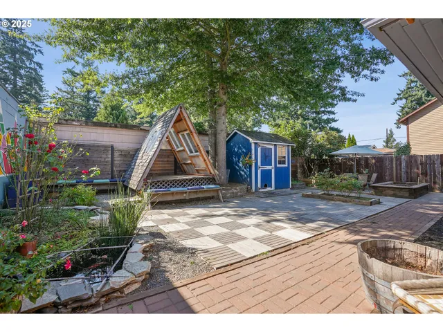 a view of a backyard that has plants and a tree