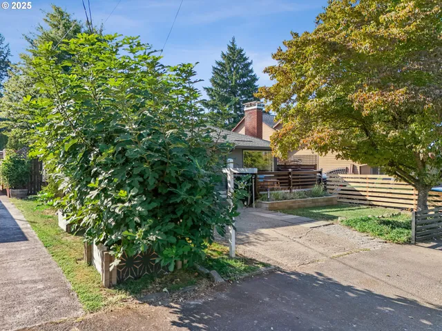 a front view of a house with a yard and a garden