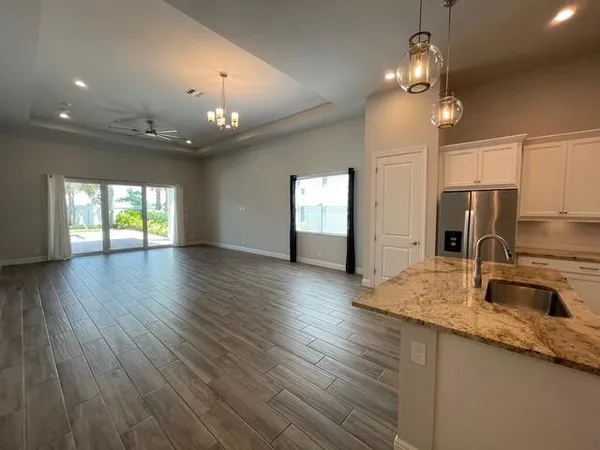 a spacious bathroom with a granite countertop double vanity sink a mirror and a bathtub