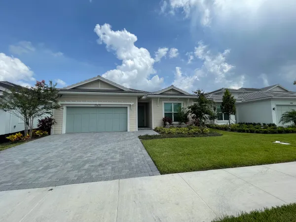 a front view of a house with a garden and a garage