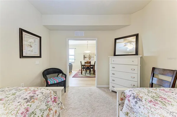 a bedroom with a bed and a flat tv screen on dresser