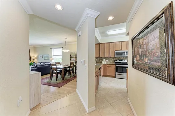 a kitchen with stainless steel appliances kitchen island granite countertop a refrigerator and cabinets