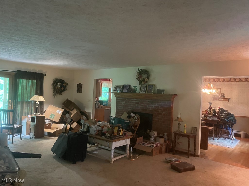 9439 Williams Road Diamond, OH 44412 - Photo 8 of 18 Living room featuring healthy amount of natural light, a textured ceiling, and a brick fireplace
