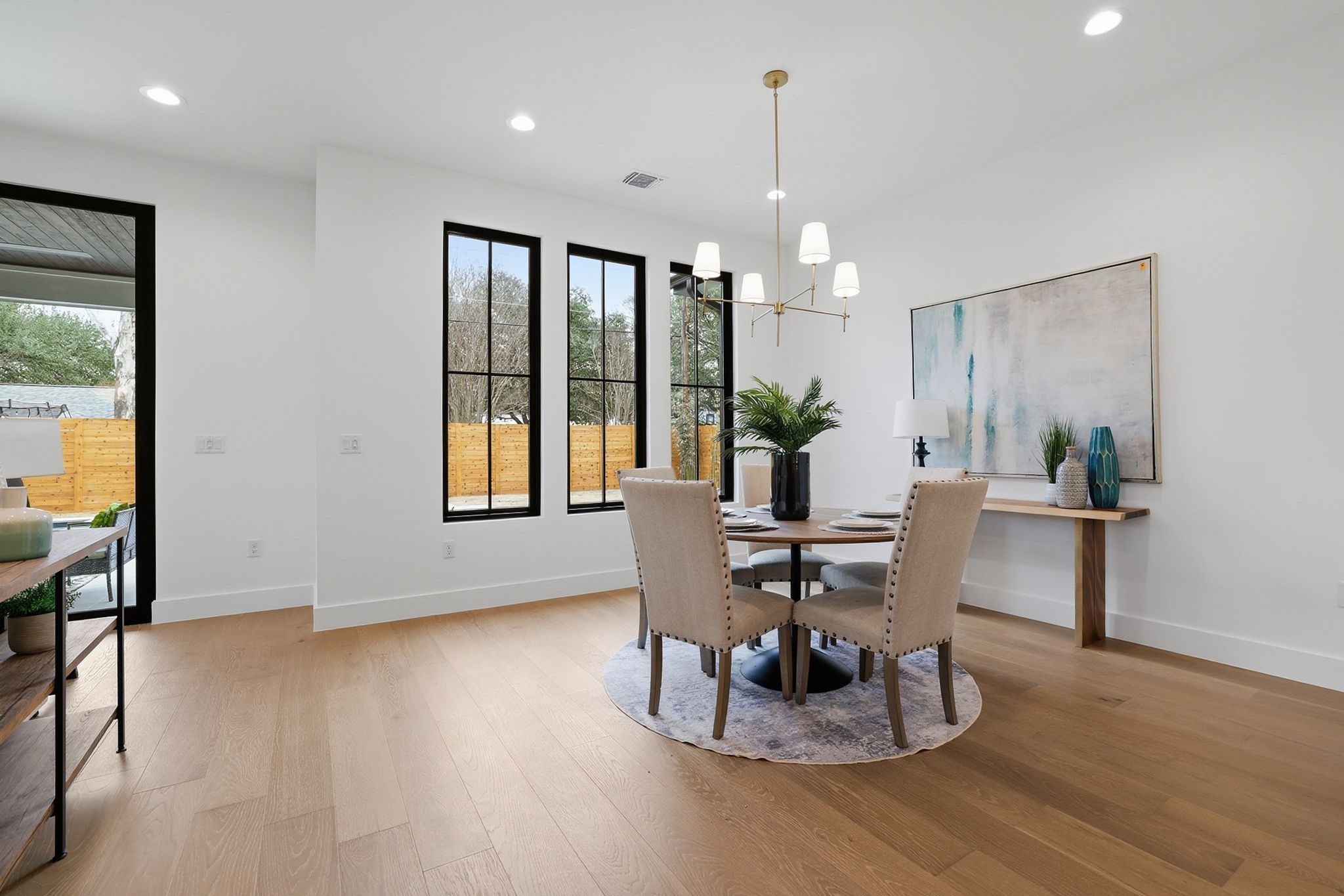 6611 Lexington Road Austin, TX 78757 - Photo 15 of 37 Open-concept dining area featuring wood-finish flooring, recessed lighting, and a modern chandelier