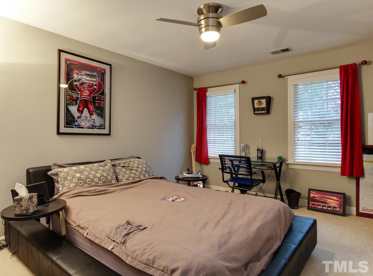 2108 Gresham Lake Road Raleigh, NC 27615 - Photo 22 of 25 a bedroom with a bed and a chandelier