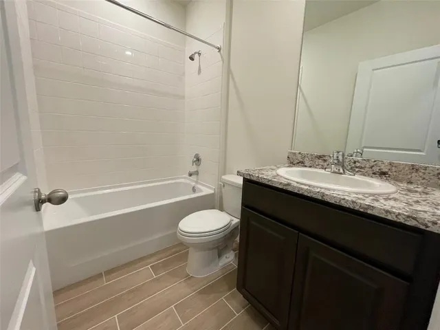 a bathroom with a granite countertop sink toilet a shower and a mirror