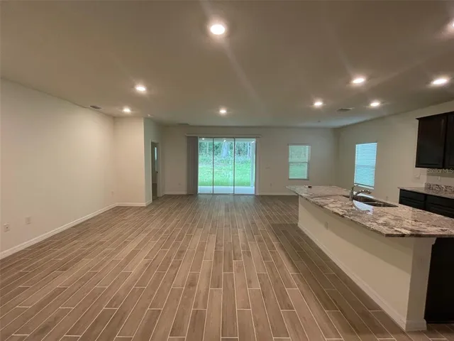 a view of kitchen island wooden floor kitchen counter and living room